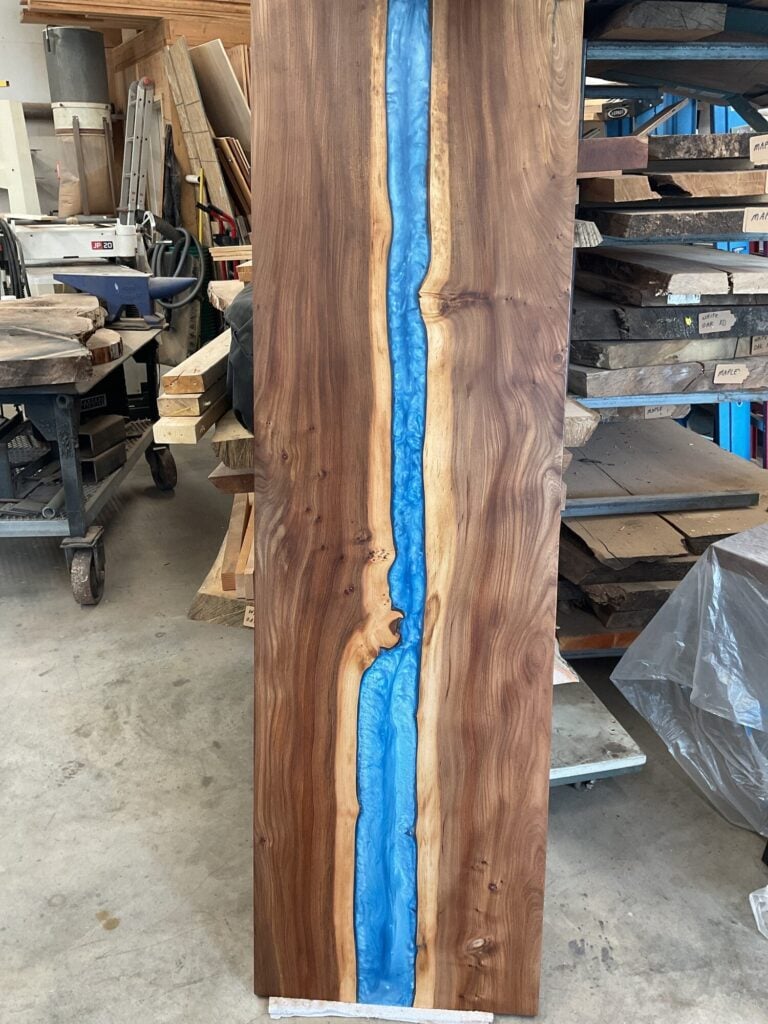 Completed blue epoxy river tabletop in walnut and elm, handmade by Jan Decor Company in Yelm WA